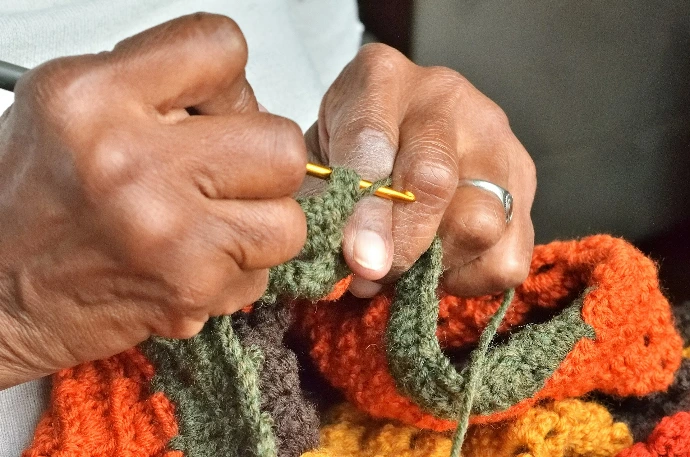 A person holding a crochet hook in their hands